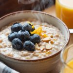 A steaming bowl of creamy overnight oatmeal topped with fresh blueberries