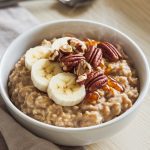 A steaming bowl of slow-cooked maple brown sugar oatmeal topped with fresh banana slices