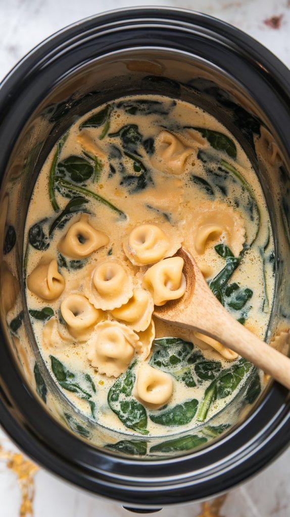 Tortellini and spinach being stirred into the slow cooker filled with soup