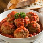 A serving of crockpot meatballs in a white bowl