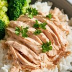 A beautiful serving of creamy shredded ranch chicken placed over a bed of fluffy white rice in a shallow bowl