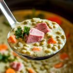 a ladle lifting creamy green split pea soup from the crockpot