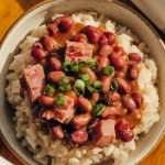 A plated serving of red beans and rice with chunks of ham