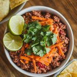 A bowl of Mexican ground beef mixture, topped with shredded cheese