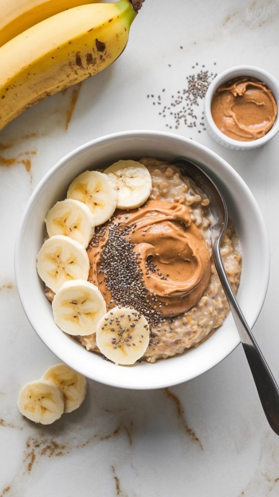 A serving of peanut butter and banana oatmeal in a white bowl