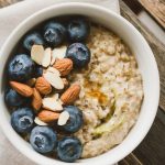 a freshly served bowl of zucchini oatmeal topped with fresh blueberries, almonds