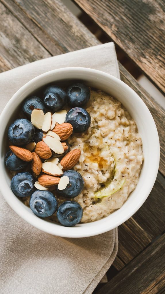 a freshly served bowl of zucchini oatmeal topped with fresh blueberries, almonds