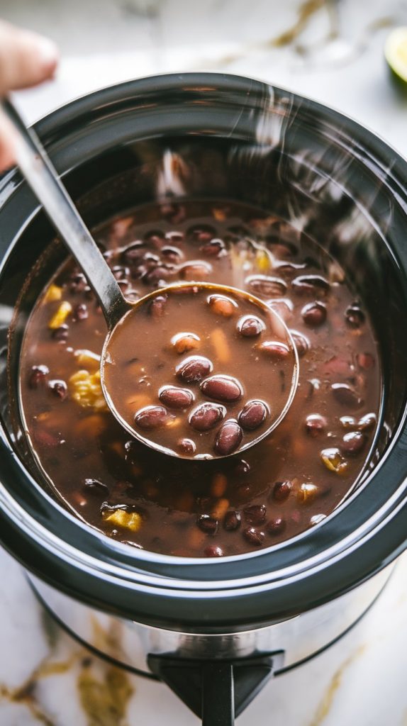 A ladle stirring fresh lime juice into a finished pot of black bean soup in the Crockpot