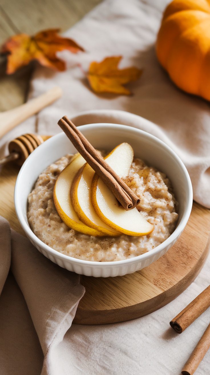 Bowl of spiced pear crockpot oatmeal topped with pear slices and cinnamon sticks, surrounded by autumn leaves.