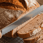 a rustic loaf of bread resting on a cooling rack, its golden crust contrasting with the soft