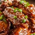 A serving platter filled with glazed Coca-Cola chicken wings