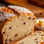 A freshly baked Irish soda bread resting on a parchment-lined cutting board