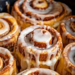 a warm cinnamon roll monkey bread in a slow cooker, freshly drizzled with icing