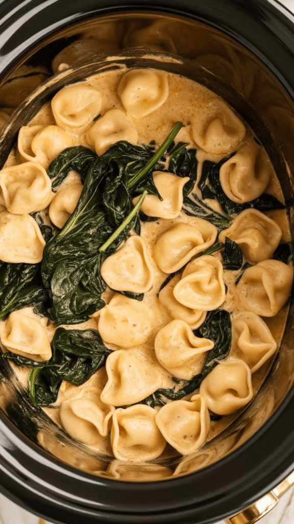 fresh spinach leaves just added to hot creamy tortellini Alfredo, starting to wilt and turn deep green