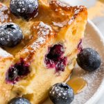 a serving of blueberry French toast casserole placed neatly on a white ceramic plate