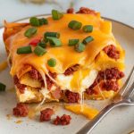 a slice of homemade chorizo breakfast casserole served on a plain white ceramic plate